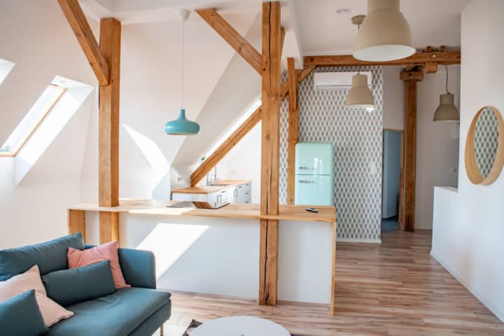 Photo d'une cuisine lumineuse ouverte sur le salon. Intérieur sous plafond avec une cuisine ouverte, et des poutres en bois - Architecture d'intérieur à Annecy et en Haute-Savoie (ArchiBienPensé)