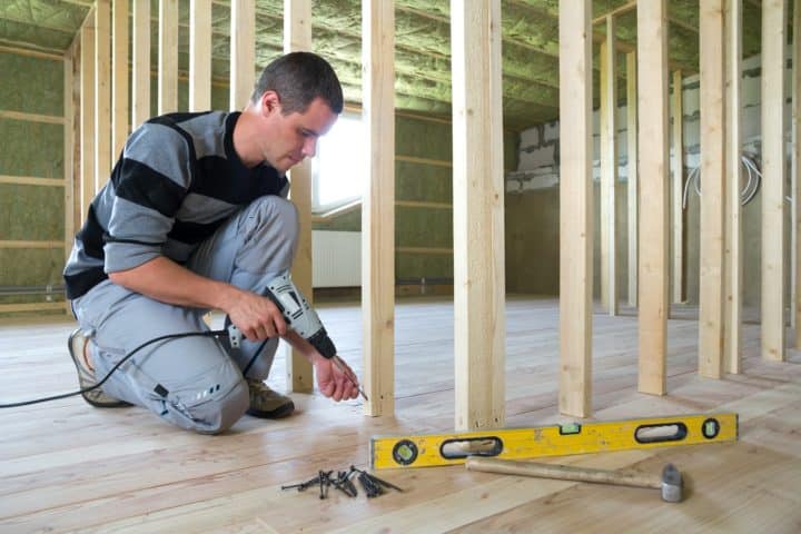 Artisan en train de poser une cloison à l'intérieur d'une maison - Maîtrise d'œuvre à Annecy et en Haute-Savoie